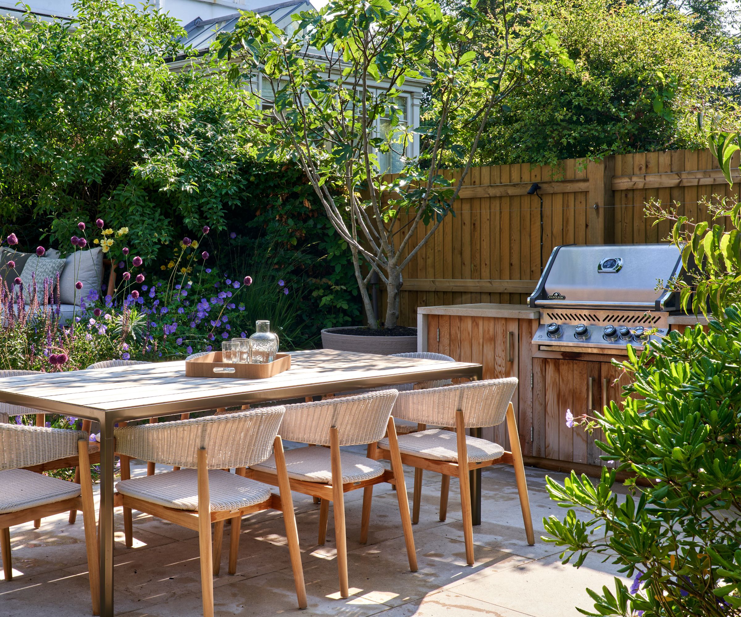A modular outdoor kitchen with wooden doors and a waterfall countertop