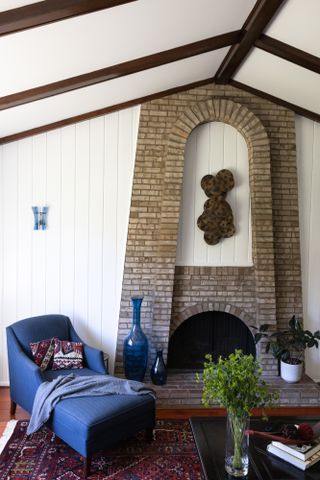 Arched brick fireplace with blue chaise longue
