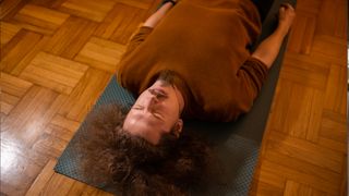 Man lying on the floor in his living room trying some kegel exercises