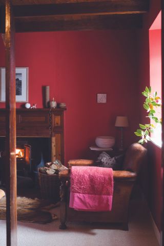Living room with red walls, leather armchair and fireplace
