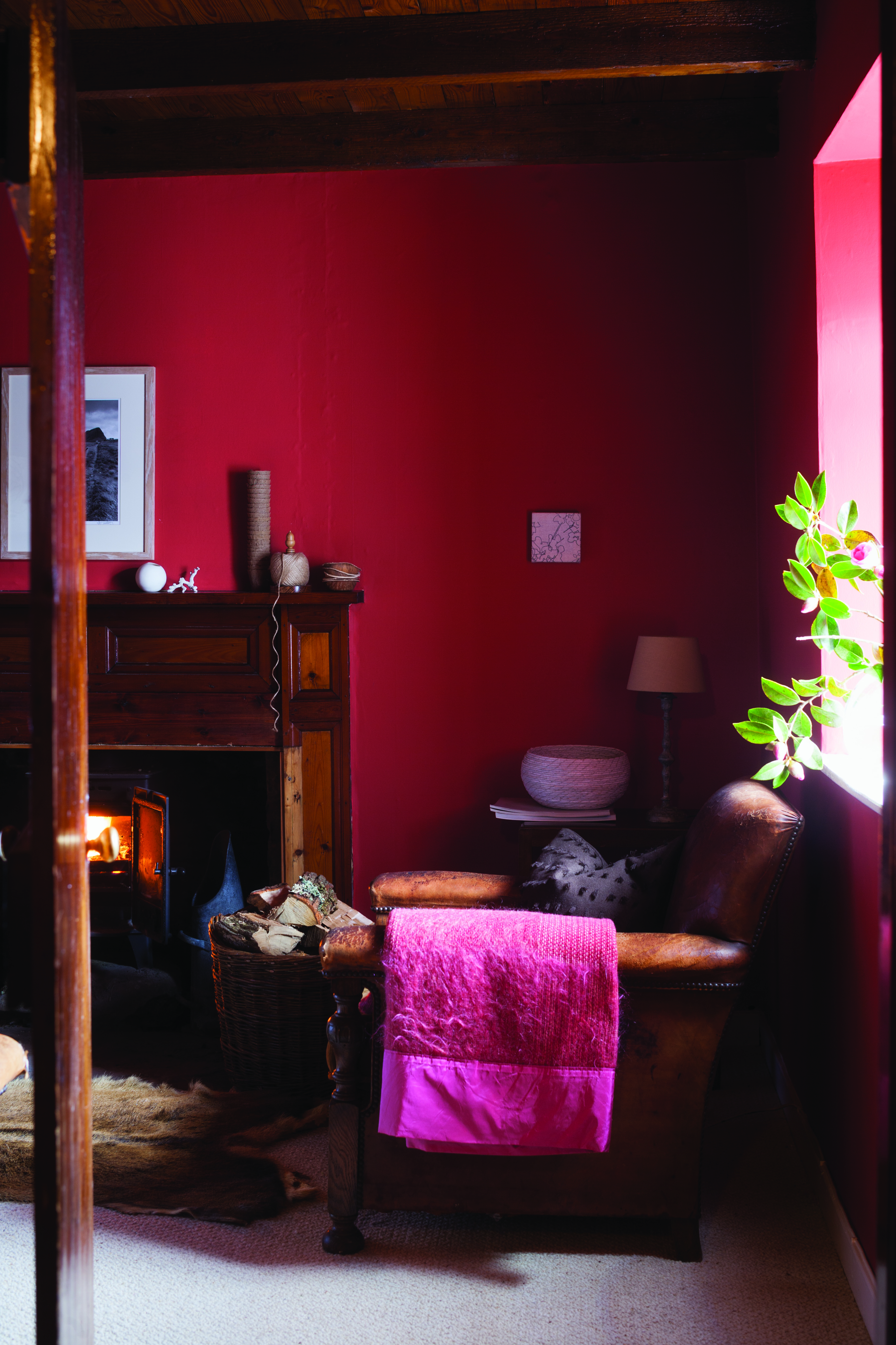 Living room with red walls, leather armchair and fireplace