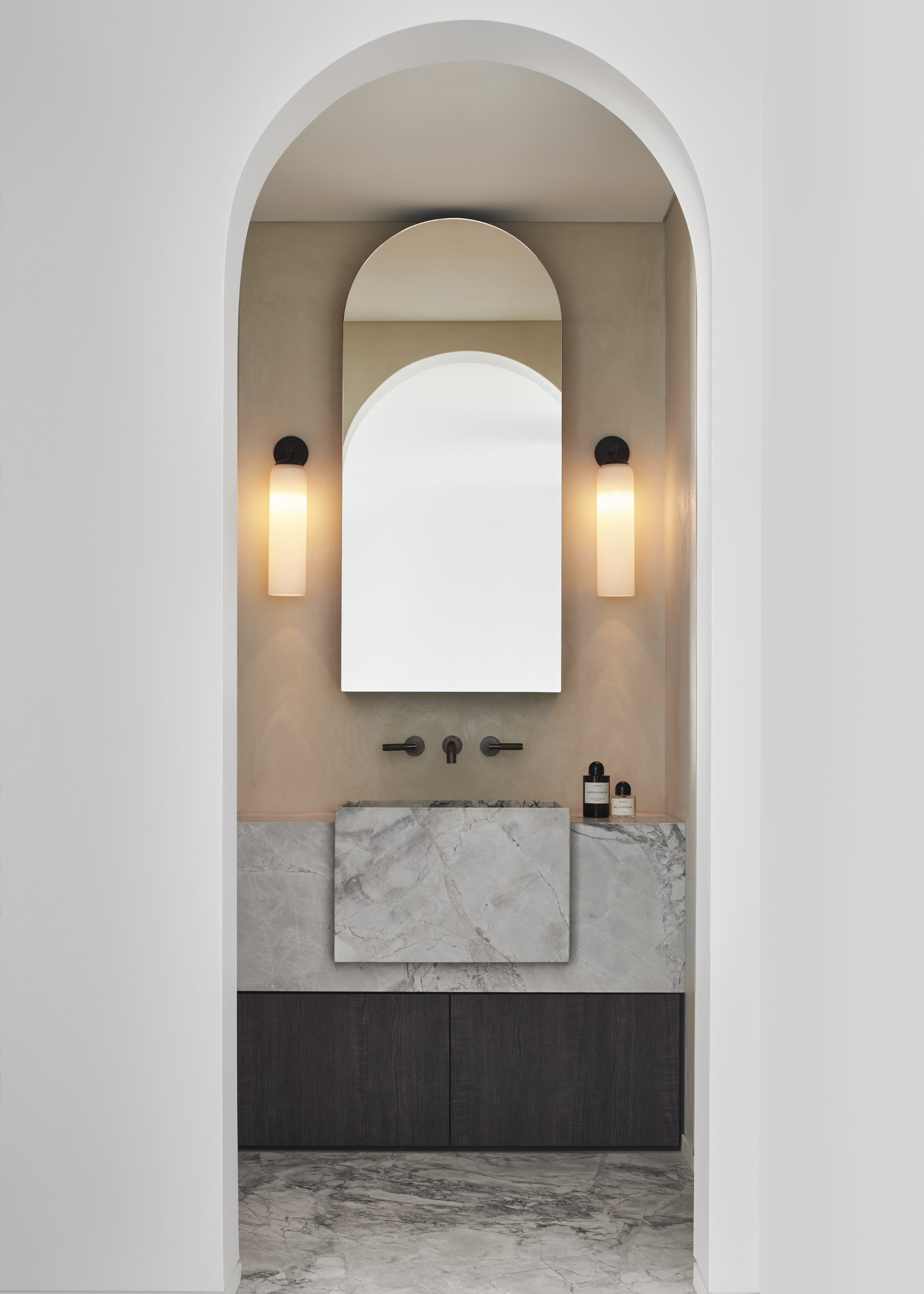 A bathroom with marble sink and limewash walls