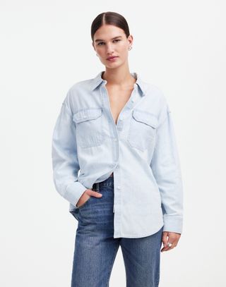 a model stands in front of a blank wall wearing a denim shirt designed by alexa chung for madewell