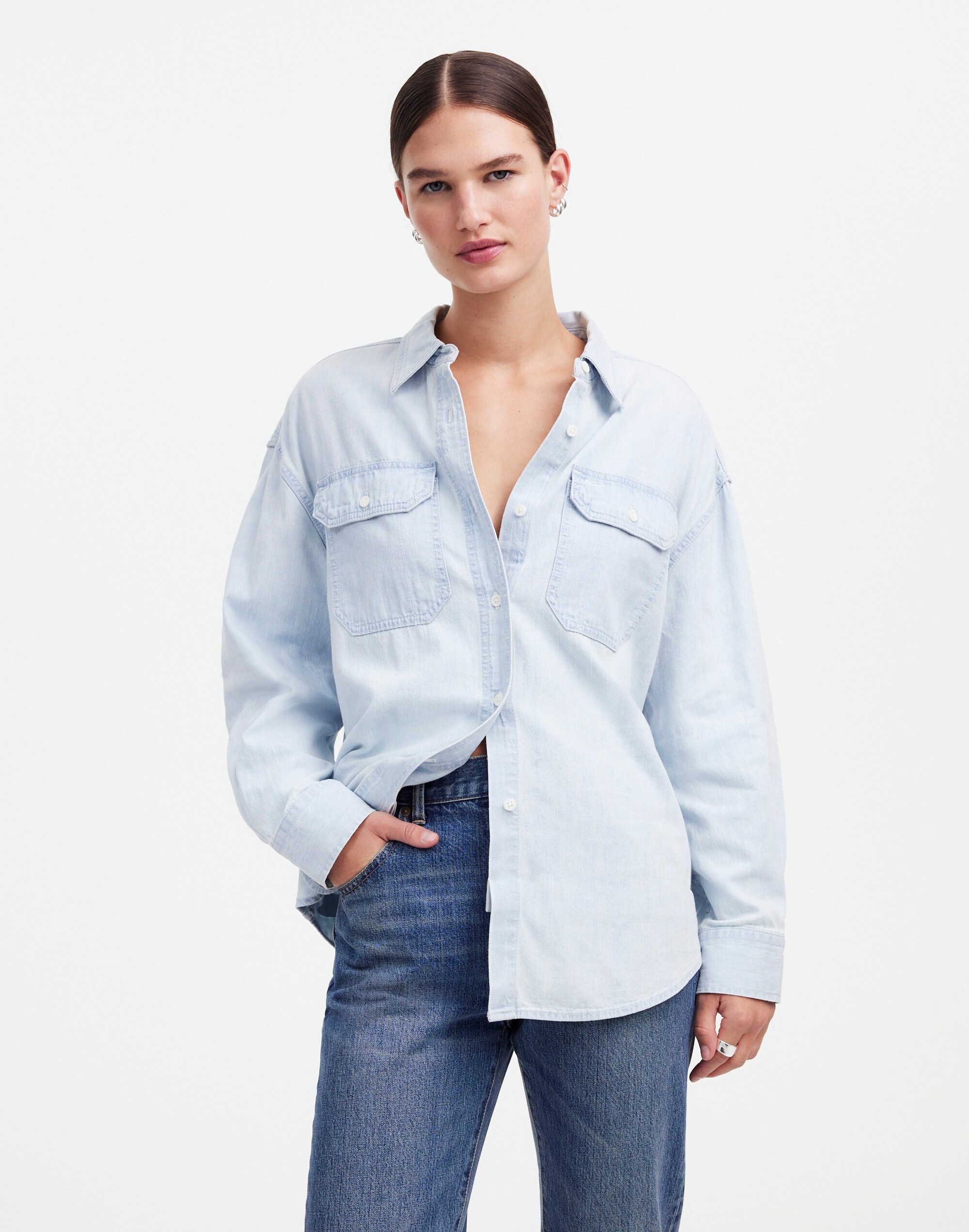 a model stands in front of a blank wall wearing a denim shirt designed by alexa chung for madewell