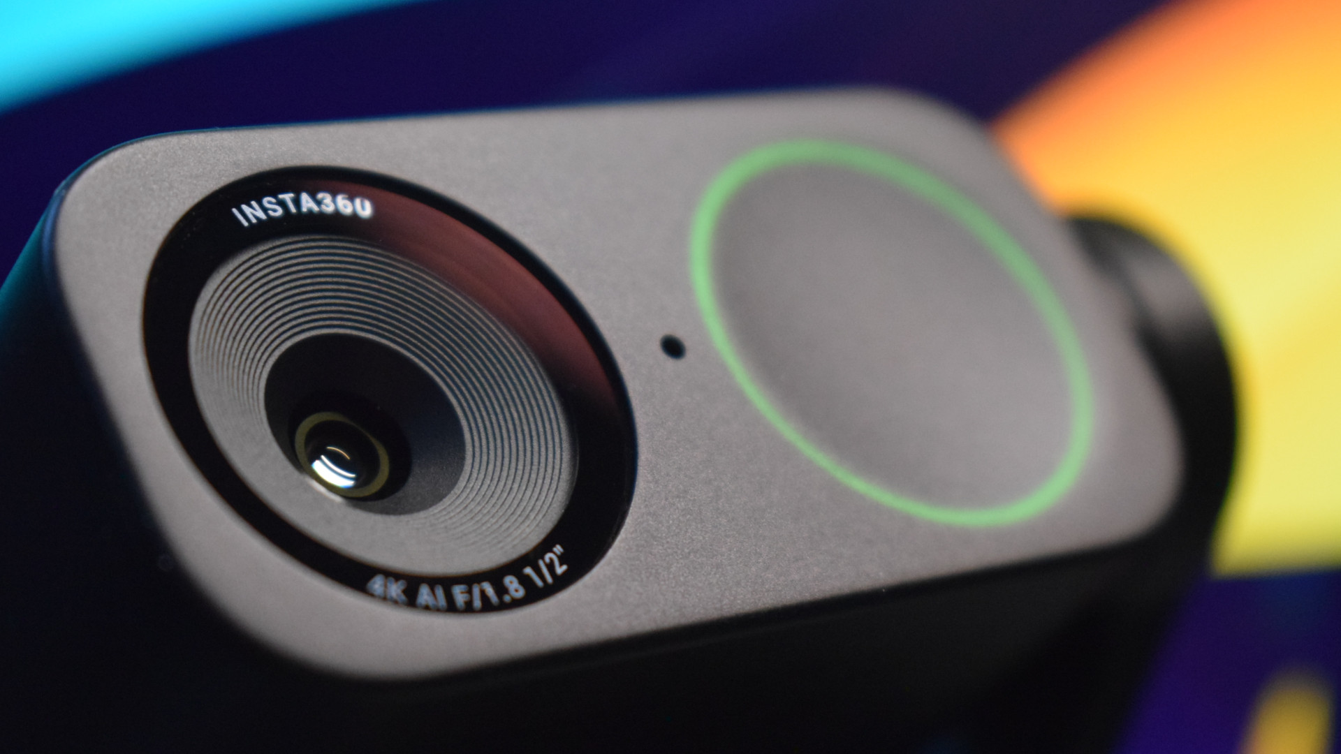 Photo of the Insta360 Link 2 4k webcam showing a close up of the camera's front element, highlighting its lens and pinhole microphone.