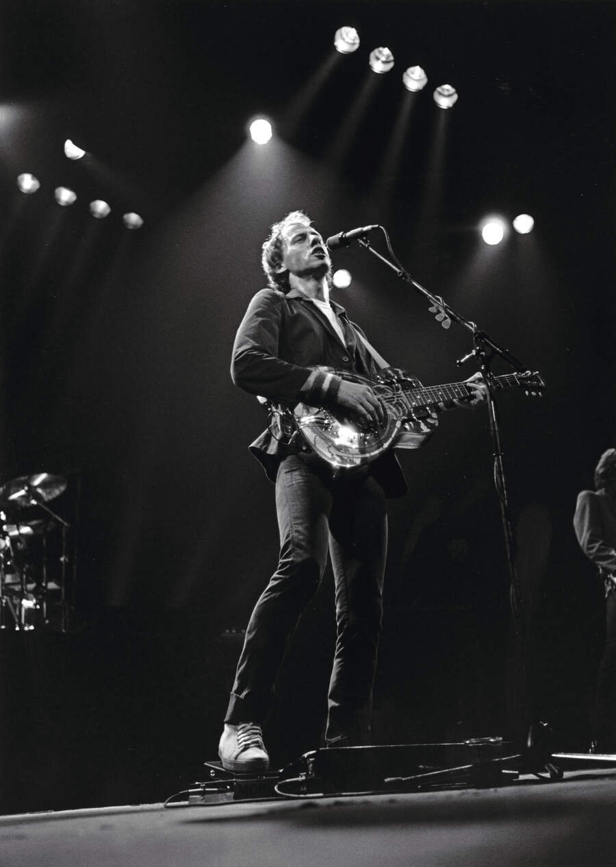 Mark Knopfler with the National resonator steel guitar pictured on the cover of Brothers In Arms.