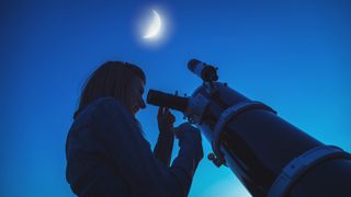 Woman with telescope looking at moon