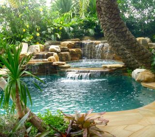 tropical garden ideas with a waterfall feature surrounded by rocks