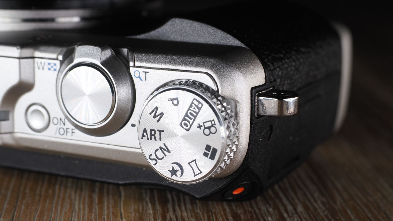 Olympus Stylus SH-3 on a wooden surface
