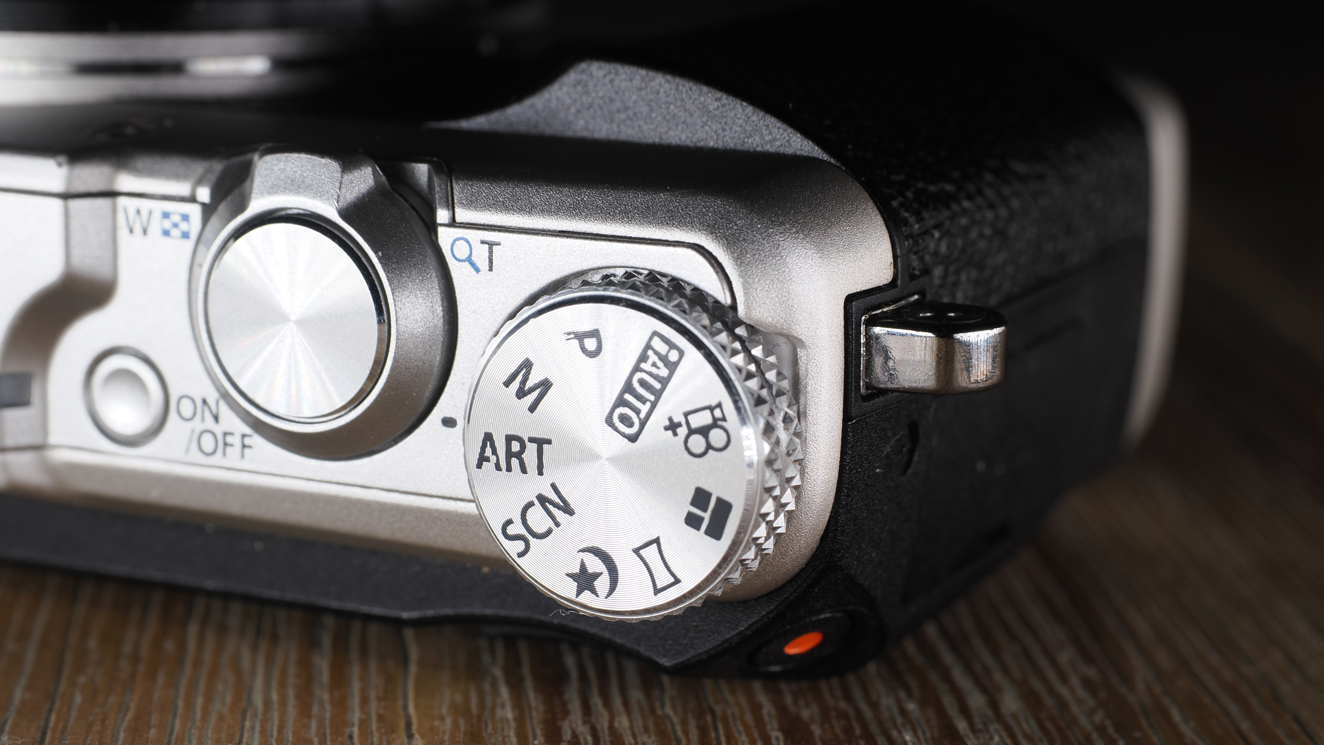 Olympus Stylus SH-3 on a wooden surface