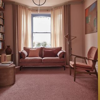 best carpet colour for living room, pink living room with pink walls, carpet and and sofa, bay window, floor lamp, armchair, bookcase