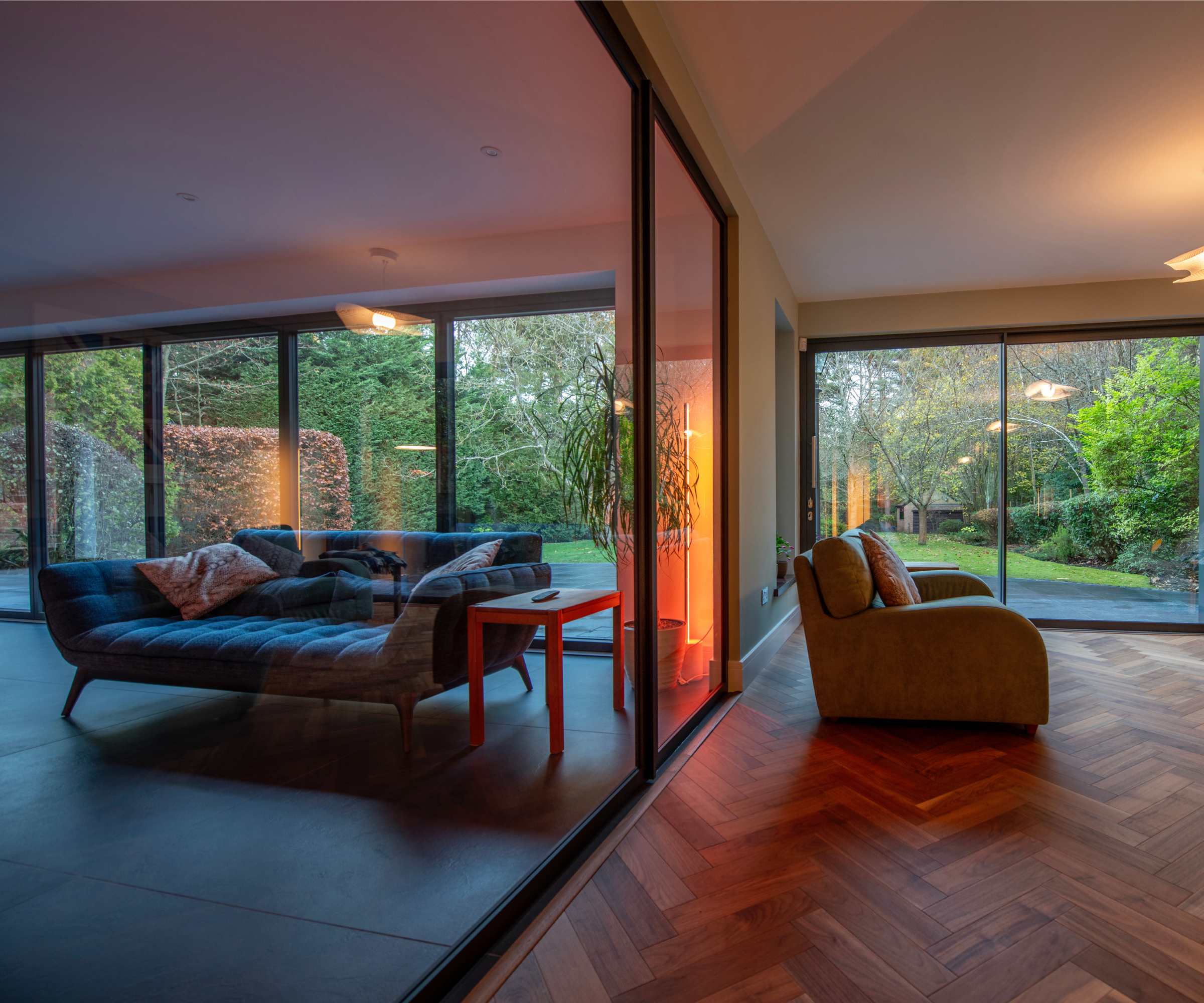 large black framed black sliding doors separating two living rooms