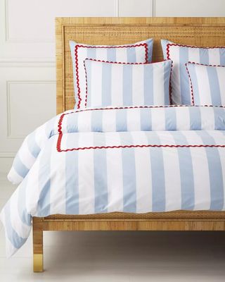 A striped blue and white bedding set with a red trim