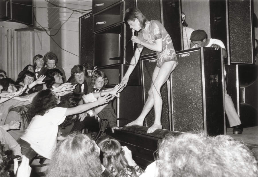 Adoring fans reaching out to touch the hand of the English pop star, David Bowie, during the concert at the Hammersmith Odeon, where Bowie announced that he was retiring his alter-ego &#039;Ziggy Stardust