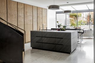 black double kitchen islands, wooden cabinetry, stone floor