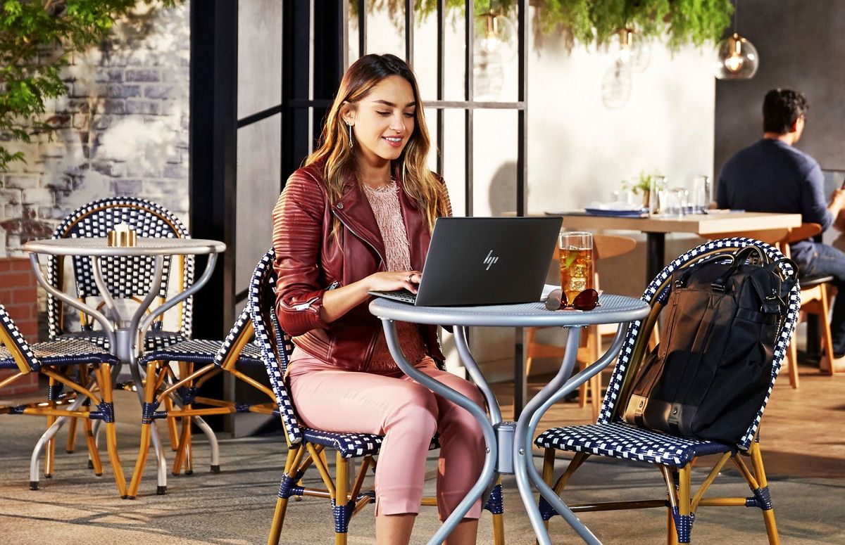 An HP Intel Evo laptop being used at a table. 