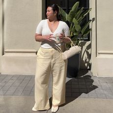 Marina wears white top and cream pants and cream tabi flats and cream freja bag 