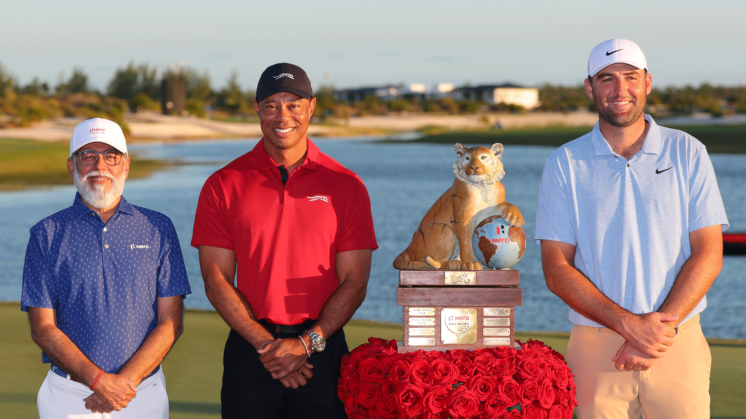 (L to R) Dr Pawan Munjal, Tiger Woods and Scottie Scheffler pose either side of the Hero World Challenge trophy in 2024