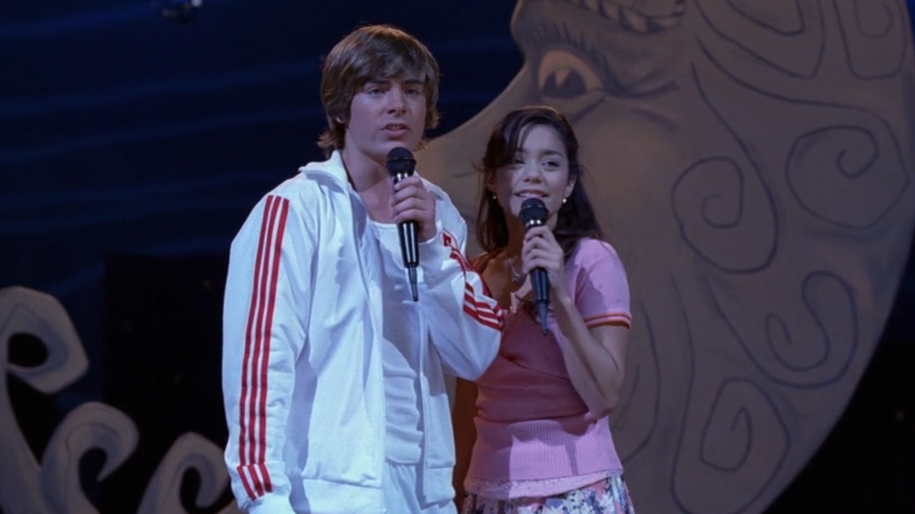 Zac Efron and Vanessa Hudgens singing on stage in High School Musical