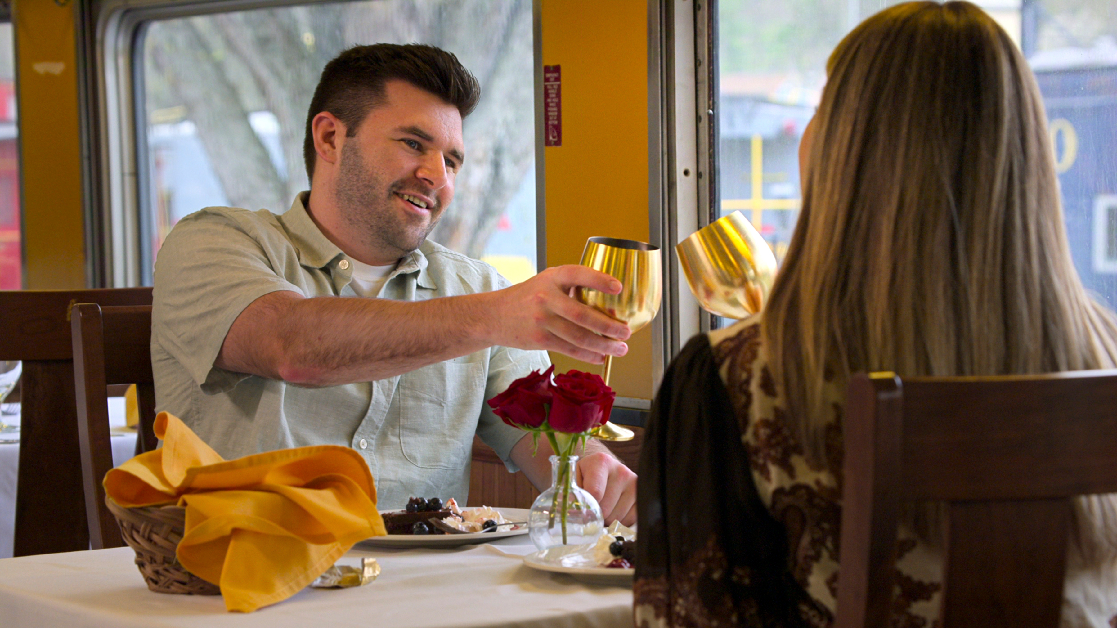 jordan and amber cheers while on a date at a white table cloth restaurant in love is blind season 10