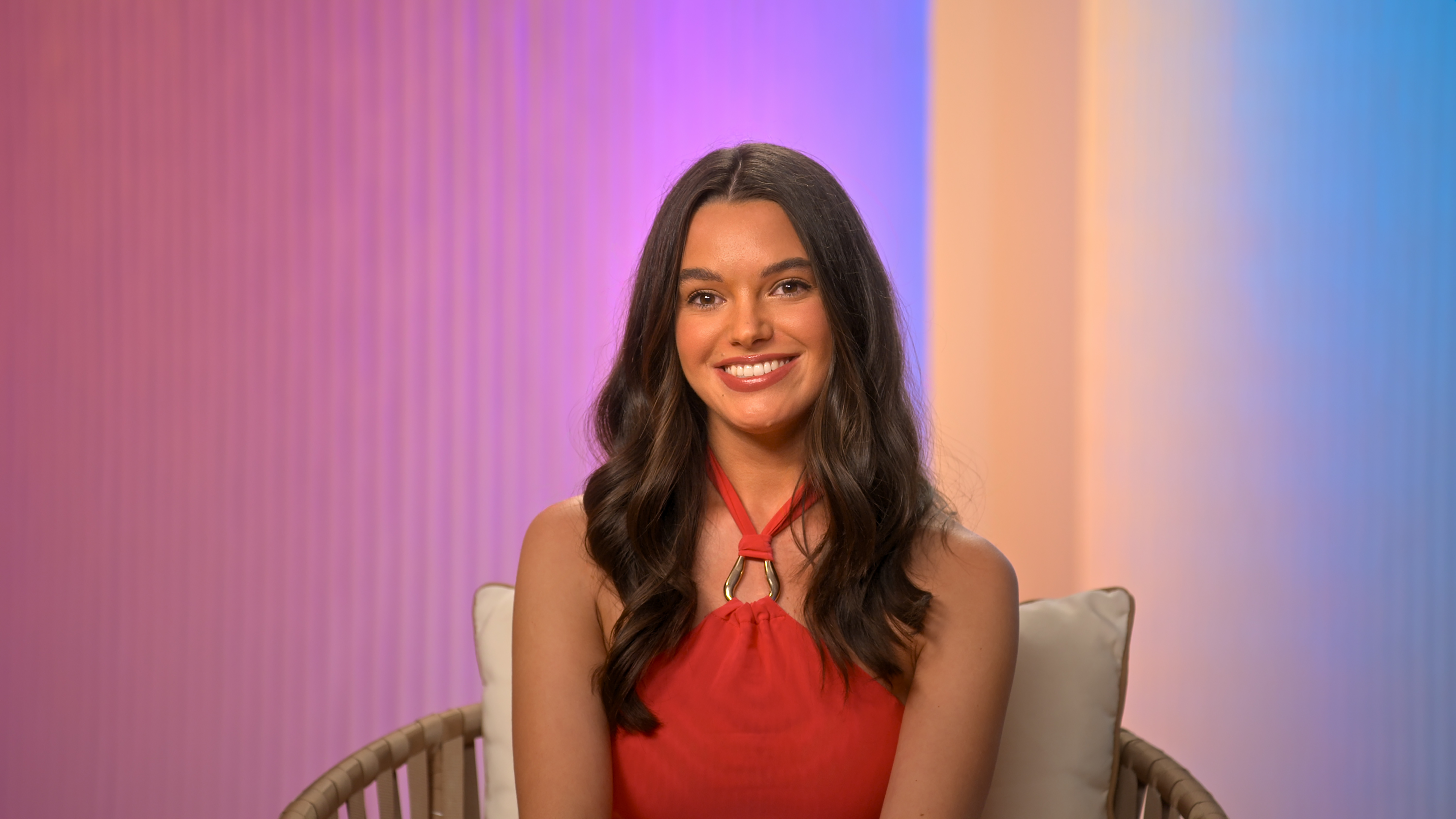 ally smiles and wears a red halter top while speaking in a confessional in perfect match season 4