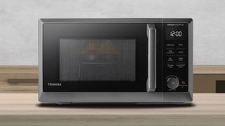 The Toshiba microwave on a wooden countertop