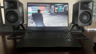 HP Victus 16 gaming laptop on a desk playing a game