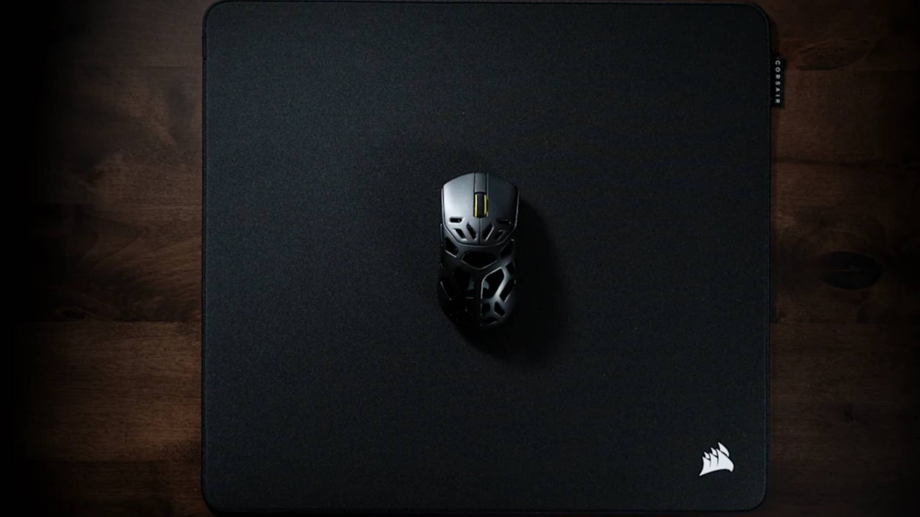 A Corsair MM Pro mouse pad on a desk, with a mouse on top.
