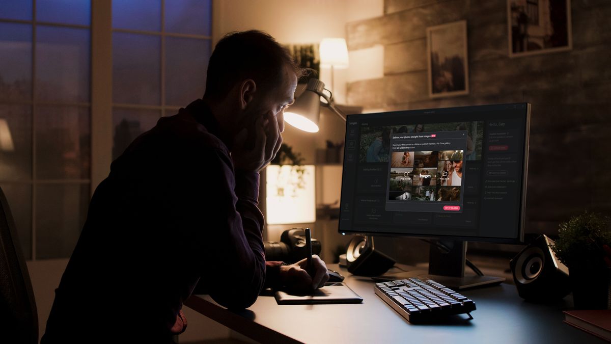 A man sat in a dimly lit room looking at Imagen software on his monitor