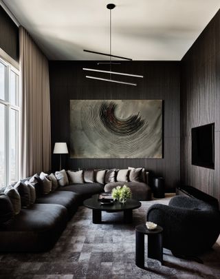 A living room with grey brought in through furnishings and pillows