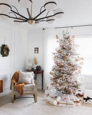 Artificial white Christmas tree with copper decorations in a living room with wood panels