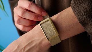 the luna band in beige photographed with the blue tom's guide background being worn by the author