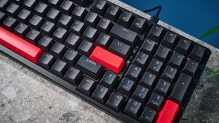 A black Lemokey X5 wired mechanical keyboard with red and black keycaps