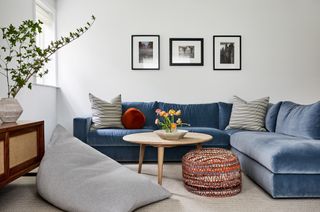 Living room with light grey walls and blue velvet sofa