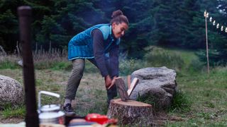 Woman breaking wooden log / best camping axes and hatchets