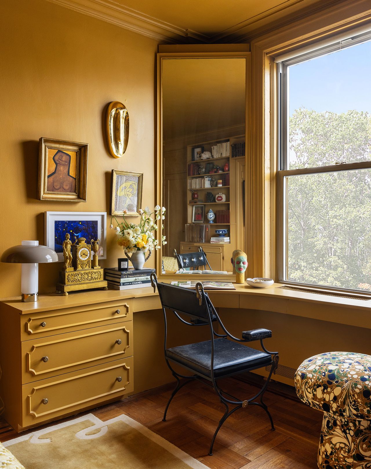 yellow bedroom with purple fan behind bed, yellow color drenched built-in desk under window