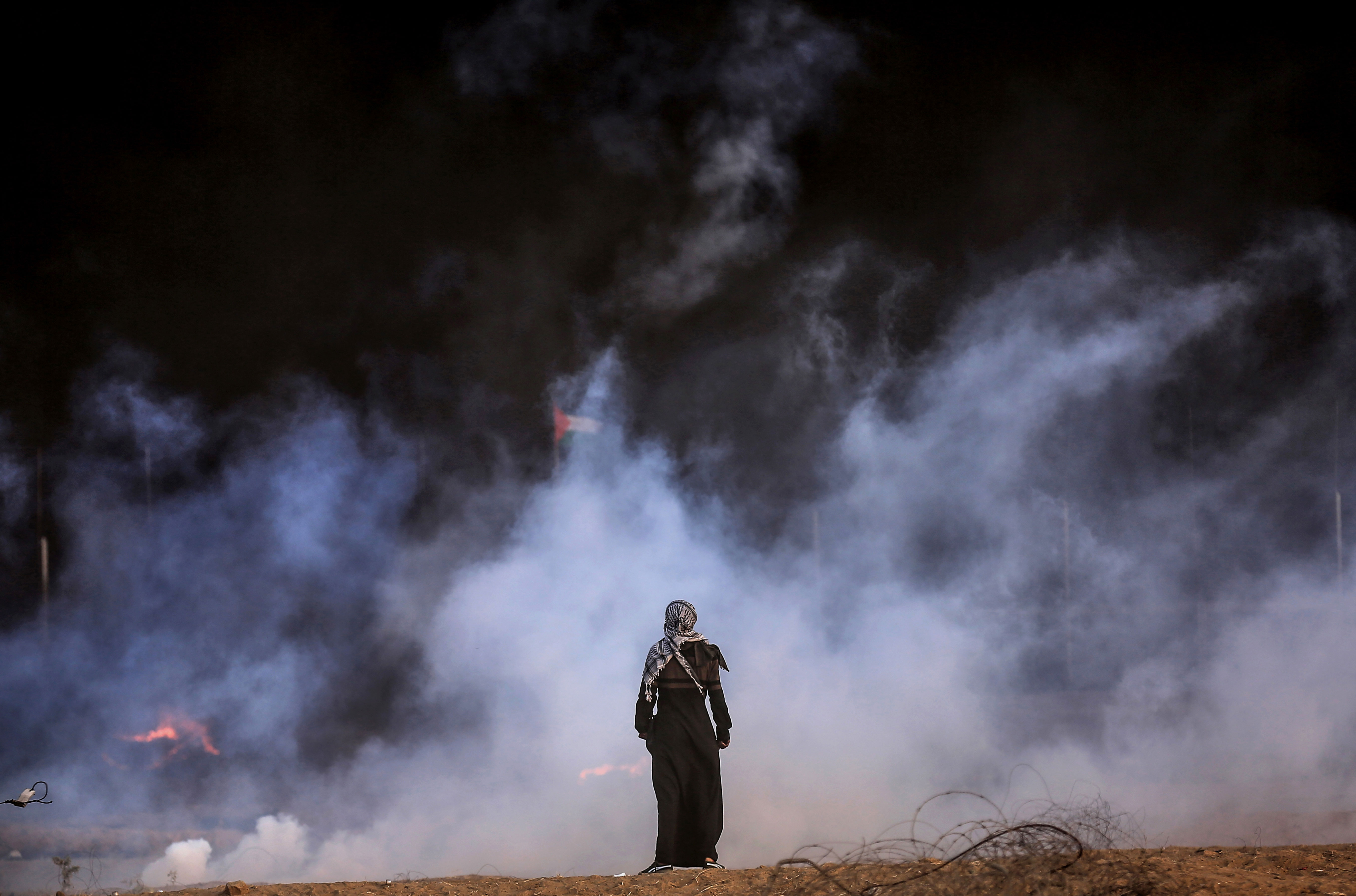 A person stands in front of a cloud of smoke