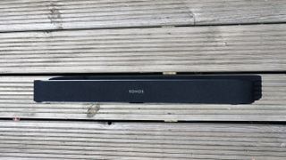 The Sonos Beam soundbar pictured on a wooden surface