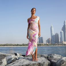 Model wearing a Quiz dress stood in front of city skyline