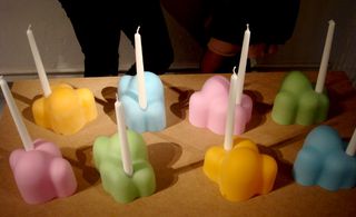 Eight small candle holders which looks like small hills and are in orange, light blue, green and pink.