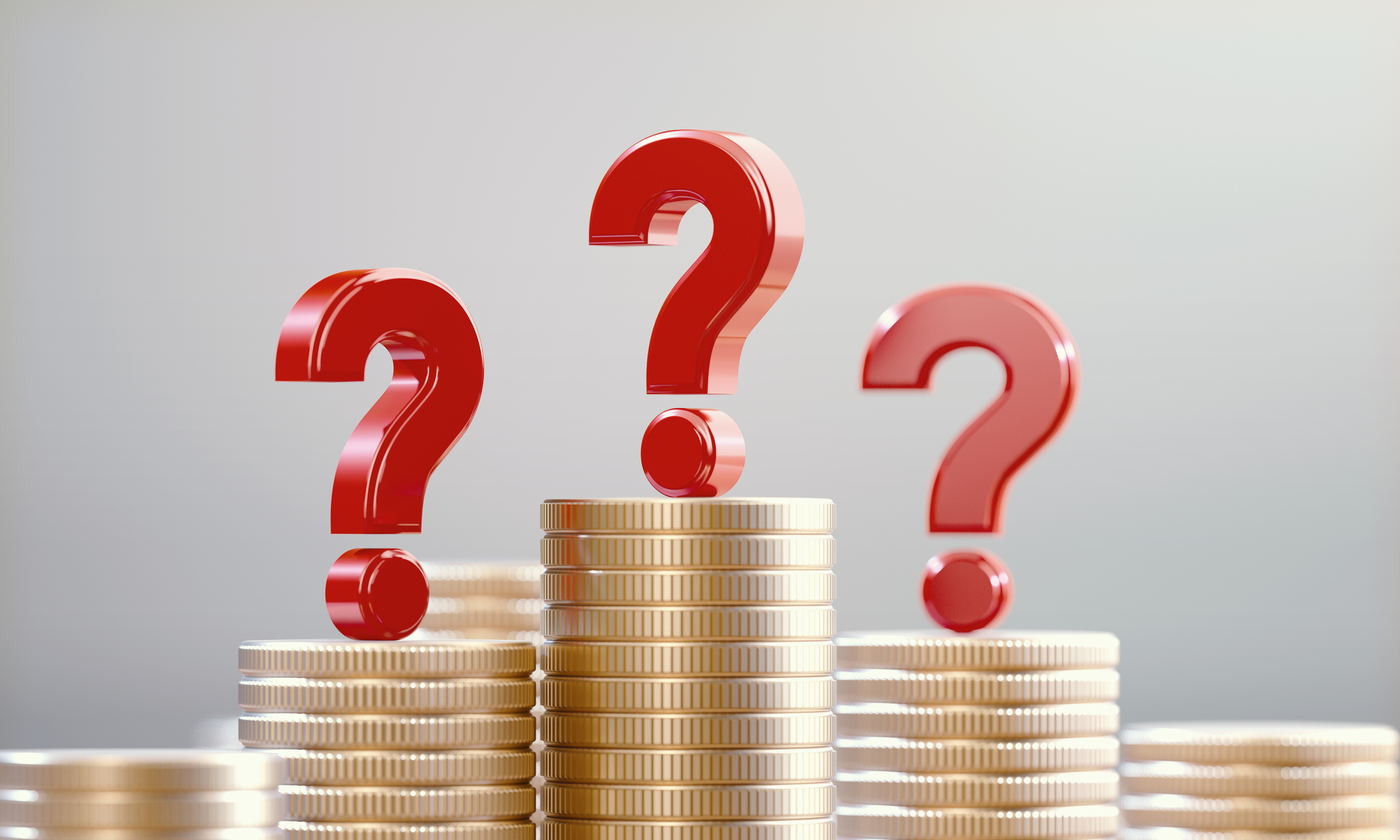 Red question marks on coin stacks before a defocused background. 