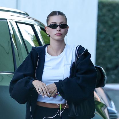 Hailey Bieber wearing chunky black sneakers with sporty yoga pants and a white T-shirt