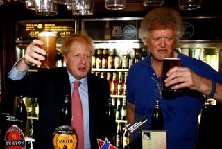Boris Johnson poses with a pint of beer next to Wetherspoons owner Tim Martin