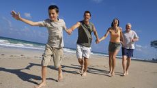 A multigenerational family walks on the beach in Florida.