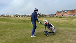 A golfer playing Royal Troon and pushing the Motocaddy M3 GPS Electric Trolley