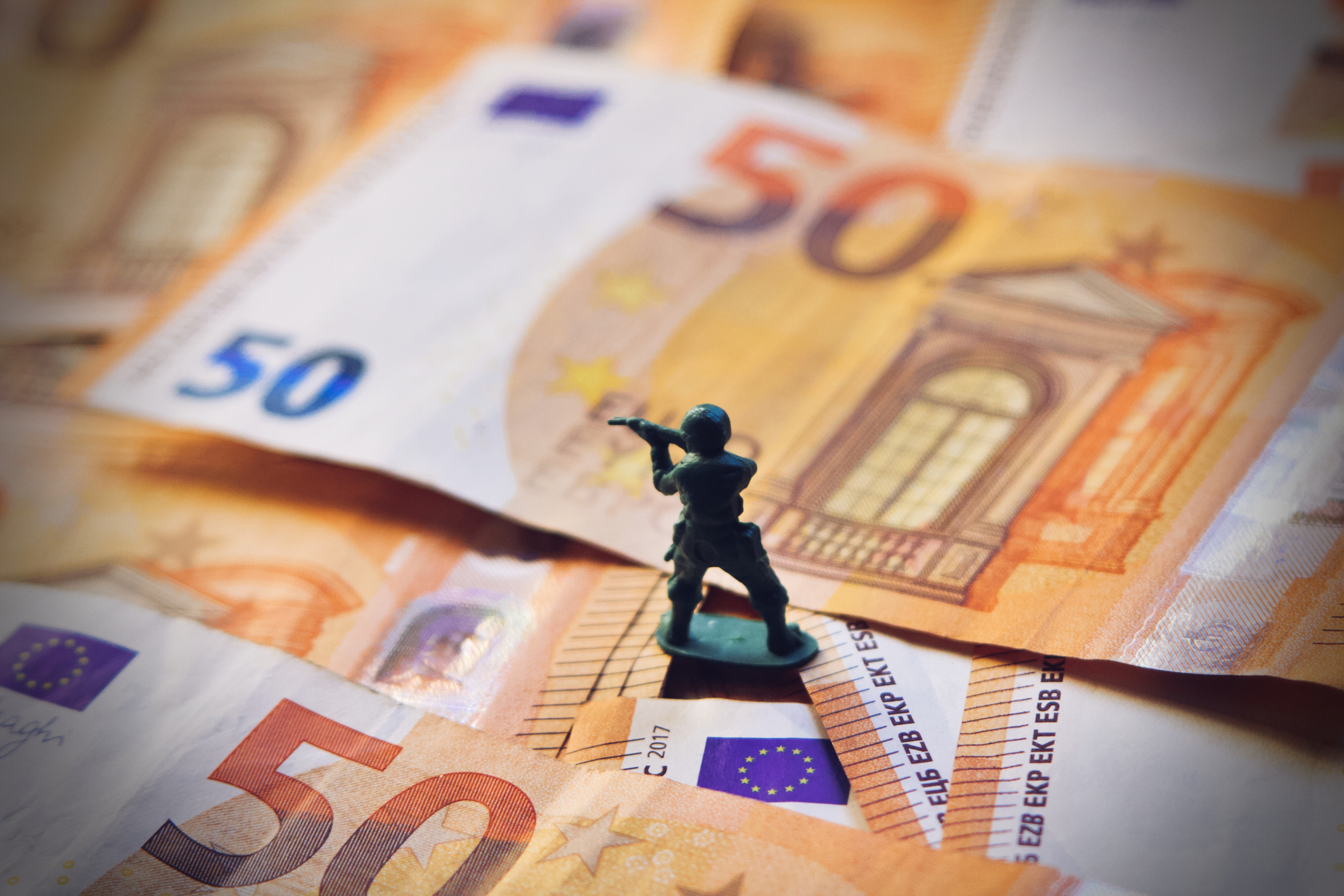 Toy soldier on Euro bills banknotes symbolising European defence spending