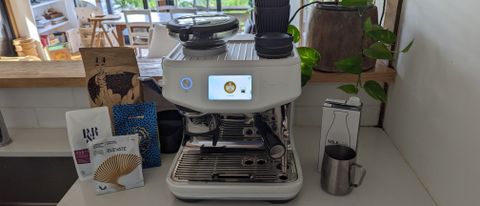 The Barista Touch Impress with fresh coffee and milk on a kitchen bench