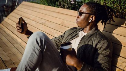 A man using his phone in the sun