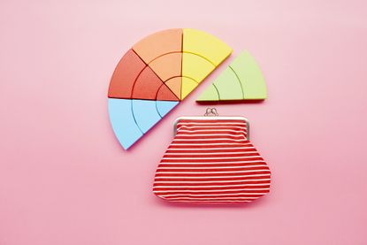 Pie chart made of colorful building blocks and wallet on pink background