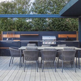 outdoor kitchen with fitted units, BBQ, sink, storage areas and dining area